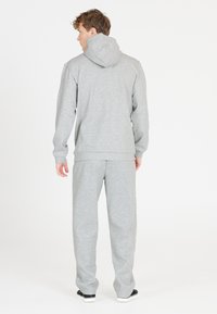 Grå hætte sweatshirtsæt med matchende joggere, lavet af blødt stof. Har en afslappet pasform samt ribbede manchetter og kant for komfort.