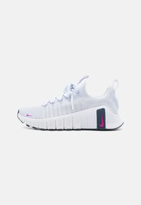 Hvit idrettssko med en teksturert overdel i stoff, rosa Nike-swoosh, fremtredende polstret såle og grå akcenter, designet for ytelse.