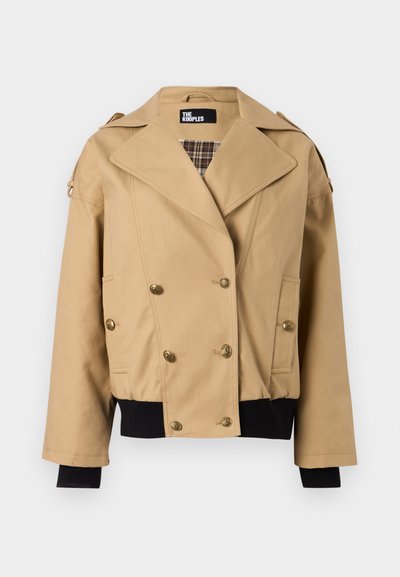 Μπεζ διπλόκουμπο σακάκι με φαρδιές πέτο, χρυσά κουμπιά, καρρώ εσωτερική επένδυση, μαύρα ριμπ μανσέτες και τελείωμα, καθώς και επιγονατίδες στους ώμους.