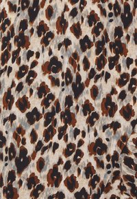 Leopard print fabric featuring black, brown, and beige spots on a light background, with a smooth texture and subtle sheen.