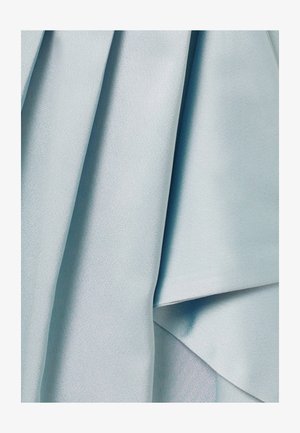 Tissu bleu clair doux à la texture lisse, présenté en plis et drapés délicats, mettant en valeur son mouvement et son éclat subtil.