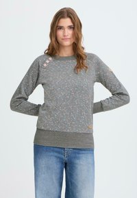 Suéter gris con patrón floral en rosa y azul, escote redondo, mangas ranglán, tres botones en el hombro izquierdo, dobladillo y puños acanalados.