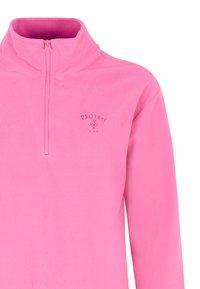 Vaaleanpunainen vetoketjullinen fleece-pullover, jossa on korkea kaulus. Röpelöinen pinta, jossa on pieni brodeerattu logo rinnassa. Pitkät hihat.