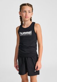 Svart ärmlös sporttop med "hummel PERFORMANCE"-logotyp i vitt. Matchad med svarta shorts med chevrondetaljer. Slät tygtextur.