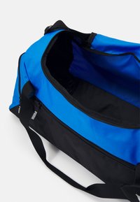 Sac de sport bleu et noir en tissu durable. Comprend un grand compartiment principal avec une fermeture éclair et des sangles de transport solides.