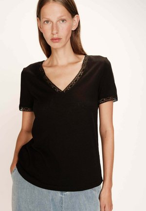 T-shirt noir à manches courtes avec un col en V, orné de dentelle autour du cou et des manches, fabriqué dans un matériau doux et fluide.