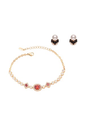 Braccialetto d'oro con tre pietre rosse circondate da piccole pietre trasparenti, abbinato a orecchini a lobo con perle e pietre nere.