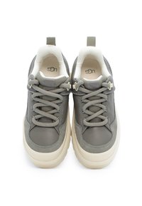 Szare sneakersy z gładką skórzaną i zamszową cholewką, sznurowanym designem, wyściełanym kołnierzem oraz kremową gumową podeszwą. Zawierają logo UGG na języku.