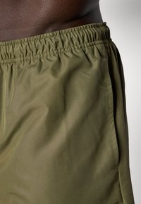 Olivi vihreät shortsit, jotka on valmistettu kevyestä, teksturoidusta kankaasta, jossa on elastinen vyötärö ja ommellut sivusaumat.
