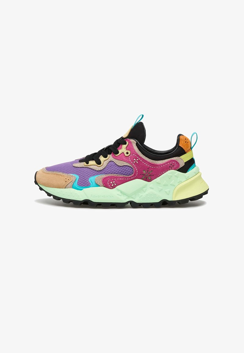 Colorful sneaker featuring a mix of purple, pink, tan, and black materials. Thick mint green sole with textured accents and black laces.