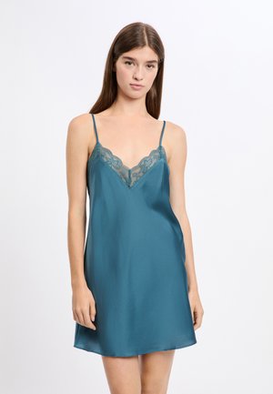 Satynowa sukienka na ramiączkach w kolorze zielonkawoniebieskim z delikatną koronkową lamówką wzdłuż dekoltu w kształcie litery V, cienkimi regulowanymi ramiączkami i gładką fakturą. Krój w kształcie litery A.