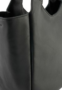Borsa tote in pelle nera con finitura textured, presenta due manici a taglio e una forma strutturata. Nessun hardware o accenti visibili.