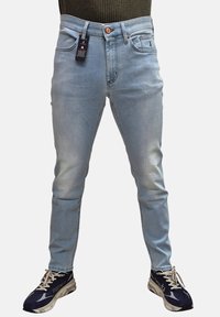 Jeans in denim azzurro chiaro con una vestibilità slim, dotati di chiusura a bottone, tasche frontali e un etichetta attaccata alla vita.