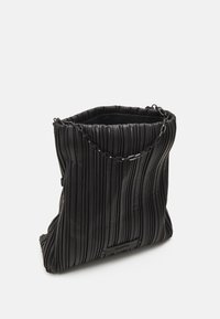 Zwarte geplooide totebag van gestructureerd materiaal, met een schouderriem van ketting en een open top ontwerp.