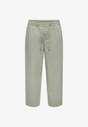 Pantalon large gris clair avec taille élastique et cordon beige, détail de couture à l'avant et longueur raccourcie.