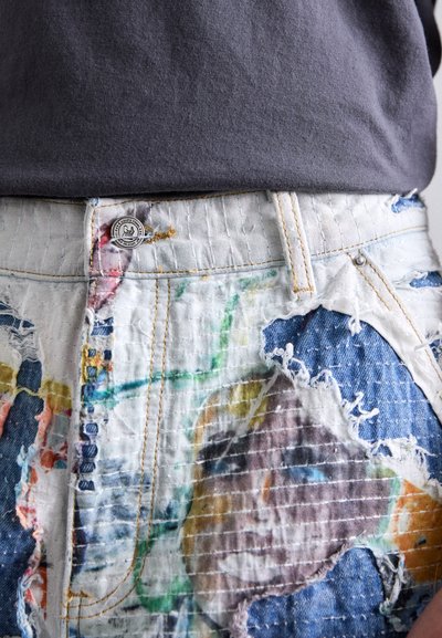 Denim shorts featuring a textured, multi-colored patchwork design with visible thread details and frayed edges; metal button hardware.
