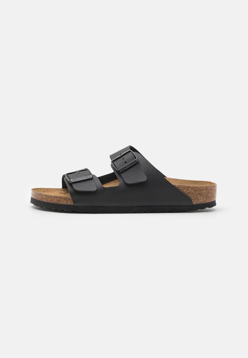 Black slide sandal featuring two adjustable buckled straps, cork footbed, and rubber outsole with textured tread for grip.