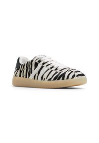 Zebra print sneakers with a textured black and white upper, white laces, and a tan rubber sole. Features a smooth black heel accent.