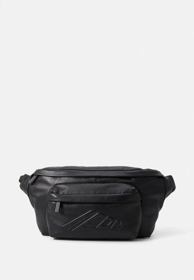 Sacoche en cuir noir avec une texture lisse, dotée d'une poche zippée à l'avant et d'un logo en relief. Forme compacte et arrondie, avec une bandoulière réglable.