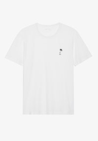 Witte katoenen t-shirt met korte mouwen en een ronde hals; bevat een kleine zwarte palmboom graphic op de linkerborst.
