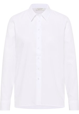 Witte langarm overhem sleutel gemaakt van een zachte stof. Beschikt over een klassieke kraag en een voorkant met knopen. Eenvoudig, strak ontwerp.