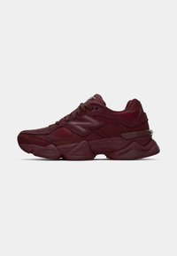 Bordeaux sport schoenen met een synthetisch bovenwerk, textuurpanelen, vetersluiting en een chunky zool met subtiele merkdetails.