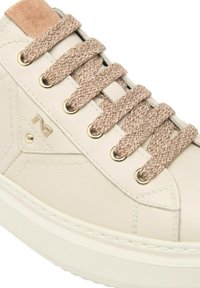 Sneaker in pelle beige con finitura liscia, dotato di lacci marrone chiaro, occhielli dorati e un'accentuazione in camoscio sul tallone.