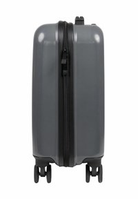 Grå hårdskalväska med en slät yta, svart dragkedja och fyra små hjul för smidighet. Har ett handtag ovanpå och en kompakt design.