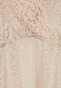 Ljusrosa spets tyg med ett fint blommönster och en mjuk, genomskinlig struktur, med en lagerdesign för ökad dimension.