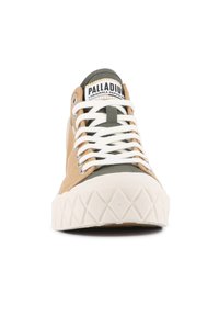 Baskets beige et vert olive avec lacets blancs, semelle en caoutchouc et capuchon de toe texturé. Étiquette de marque bien visible sur la languette.