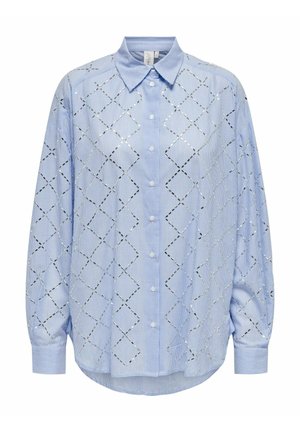 Svijetloplava oversized košulja s gumbi, s vertikalnim prugama i romboidnim izrezima obrisanim u crnoj boji. Ima klasični ovratnik i duge rukave.