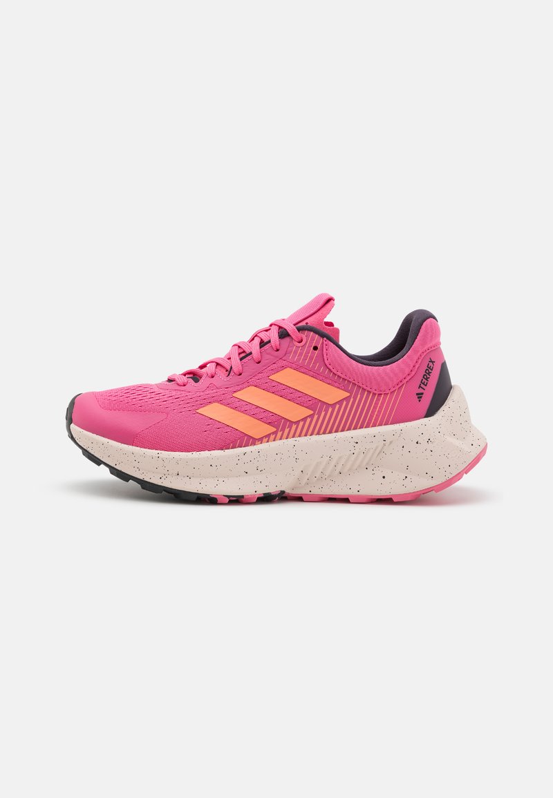 Zapatilla de running Adidas Terrex en color rosa brillante con rayas coral, forro interior negro y suela moteada beige sobre fondo blanco.