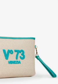 Pochette con zip lavorata a maglia in beige naturale con testo ricamato turchese "V°73 VENETIA." Presenta una tracolla coordinata e una superficie texturizzata.