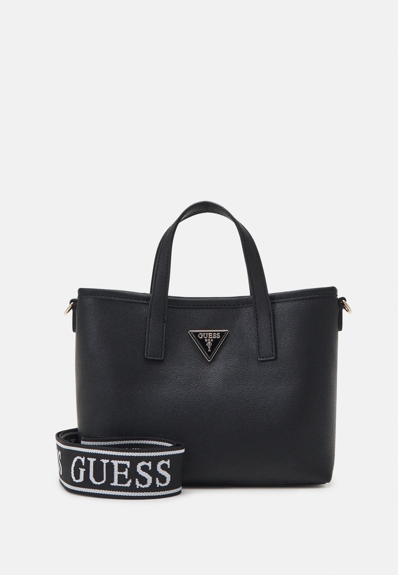 Sac à main en cuir noir avec deux poignées supérieures et une bandoulière amovible arborant le logo blanc GUESS, plaque logo triangulaire GUESS à l’avant.