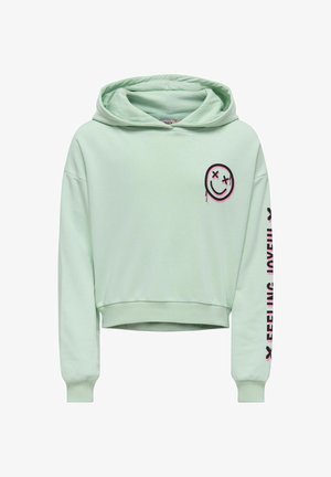 Miętowy krótki hoodie z czarnym i różowym graficznym uśmiechniętą twarzą na klatce piersiowej oraz napisem "FEELING JOYFUL" wydrukowanym na różowo wzdłuż rękawa.