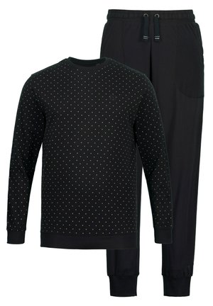 Sort loungewear-sæt bestående af en langærmet bluse med hvidt prikmønster og matchende bukser med elastisk talje og manchetter.