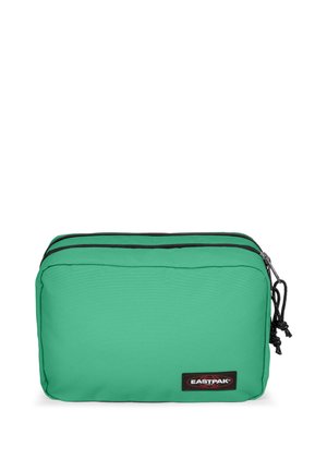 Green fabric cosmetic bag with dual zippers, black trim, and a logo patch. Rectangular shape with a smooth texture and drawstring accents.