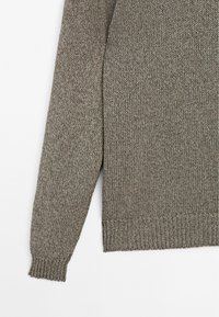 Brązowy sweter dziany o teksturowanym wzorze, z ściągaczem przy mankietach i dolnym wykończeniu oraz wygodnym kroju.