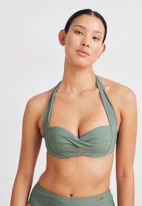 Žalias bikini viršus su viršuje rišamu kaklo dizainu, su sukta priekiu ir švelnia tekstūra. Paprastas ir elegantiškas, be papildomų ornamentų.