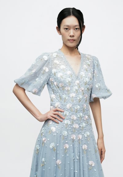 Ljusblå klänning med kort puffärm, V-ringning, intrikat broderade blommönster och subtila paljetter, med en flödande kjol.