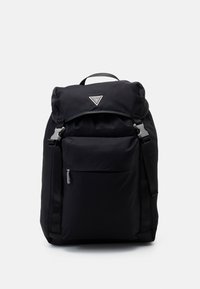 Mochila de nylon negra con parte superior enrollable, herrajes plateados, bolsillo con cremallera en la parte frontal y correas ajustables. Presenta un logo en la parte delantera.