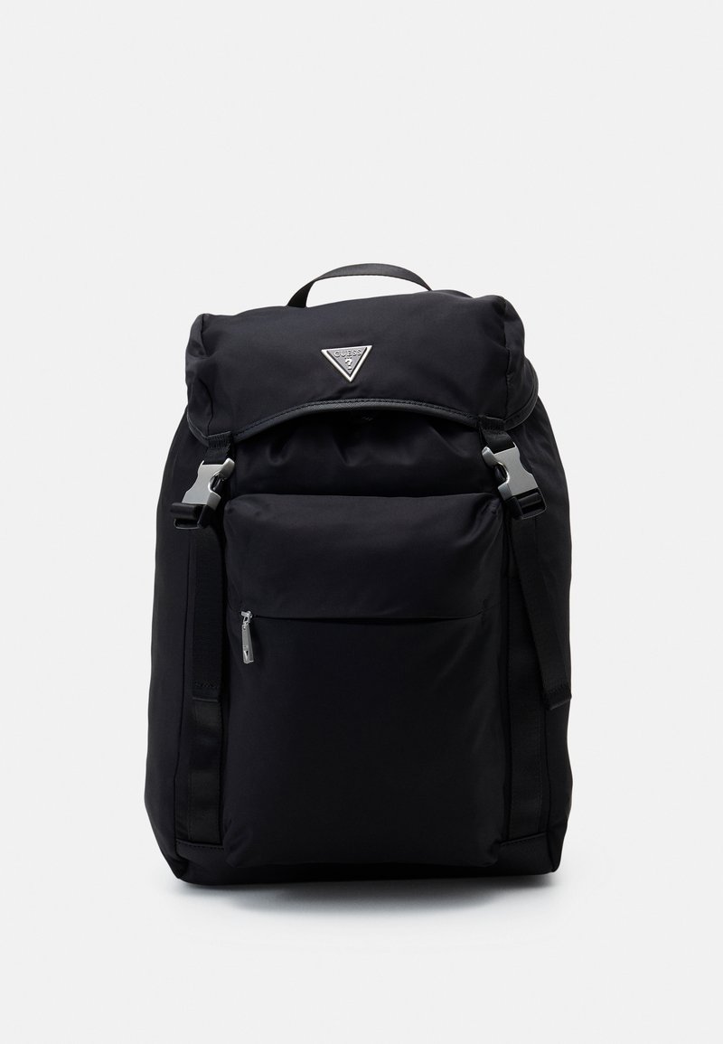 Mochila de nylon negra con parte superior enrollable, herrajes plateados, bolsillo con cremallera en la parte frontal y correas ajustables. Presenta un logo en la parte delantera.