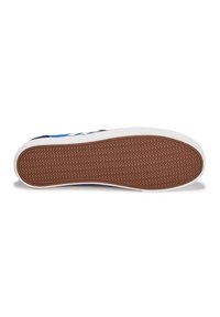 Scarpa con suola in gomma caratterizzata da un motivo a zigzag, tomaia blu, dettagli bianchi e un colletto imbottito e testurizzato per il supporto.