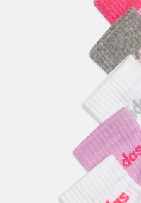Chaussettes en coton colorées pour la cheville en rose, blanc, gris et à motif. Présente une texture côtelée et du texte imprimé sur certaines.