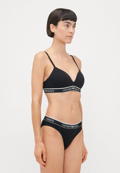 Black lingerie set featuring a triangular bra with thin straps and logo band, paired with matching hipster panties, also with logo detail.