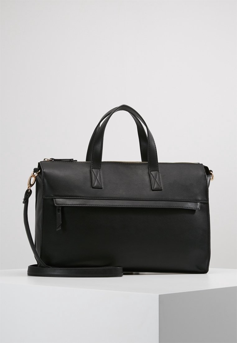 Sac en cuir noir avec deux poignées supérieures, bandoulière amovible, poche avant, design plat, texture lisse et accents de quincaillerie dorée.