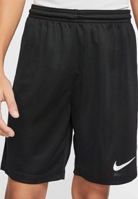 Svarta Nike-shorts som har ett strukturerat tyg, elastiskt midjeband med tredubbla sömmar och en kontrasterande vit logotyp på vänstra fållen.