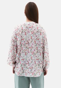 Blusa leggera con stampa floreale nei colori rosa, verde e bianco. Presenta maniche lunghe, una vestibilità comoda e un orlo curvo.
