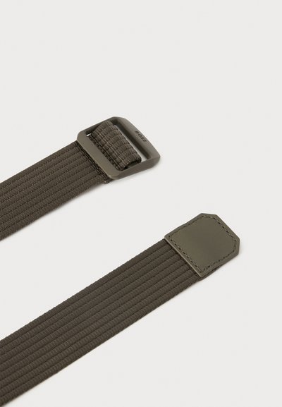 Ceinture en tissu élastique vert olive foncé avec boucle métallique rectangulaire et languette en cuir cousue sur un fond clair.