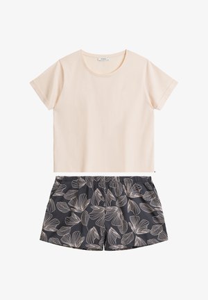 Jasnoróżowa bluzka z krótkimi rękawami w połączeniu z czarnymi szortami z białym wzorem liści. Miękka tkanina, luźny krój, elastyczny pasek w szortach.